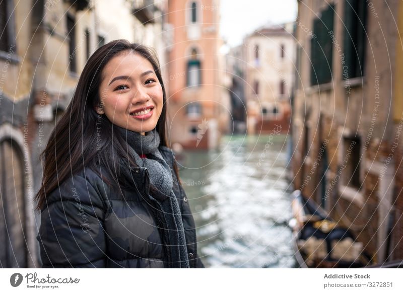 Satisfied Asian resting woman exploring old city with waterways tourism waterline building ancient historical smile enjoy travel vacation walk explore asian