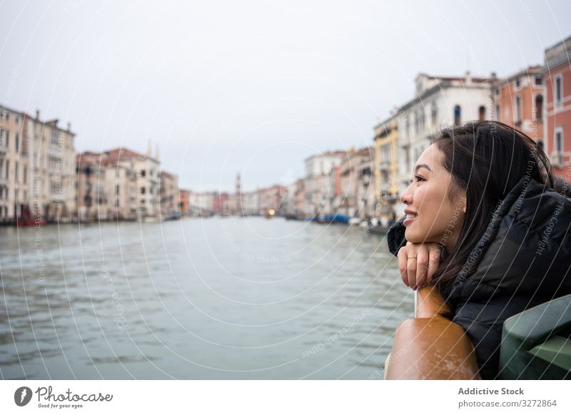 Asian female on vacation ob ferryboat on waterline at city tourist way enjoy smile laugh asian street old ancient historical buildings travel sky view canal