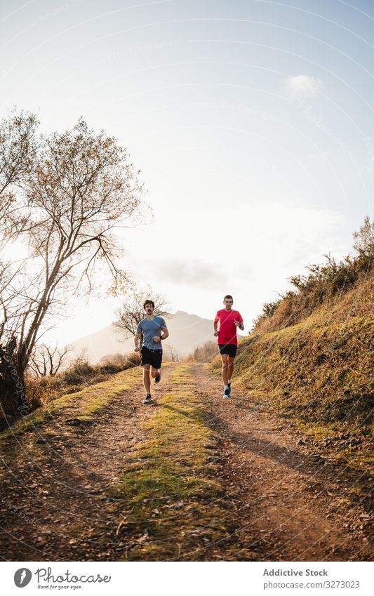 Sportive men running in mountains sportive active jogger nature road sportsmen inspiration together morning freedom training trail cross country path dirt male