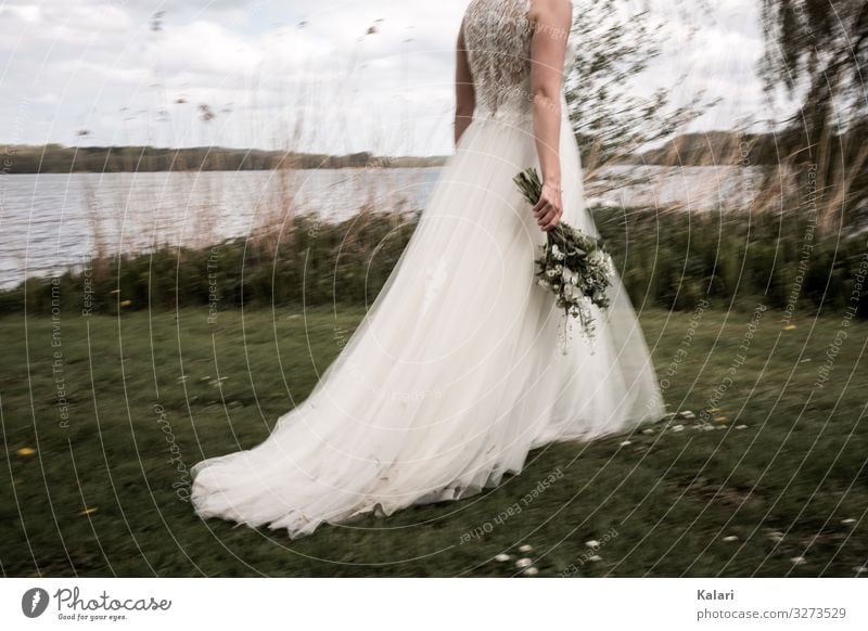Bride walks with bouquet over meadow Wedding dress Going bridal bouquet Meadow Dress blurred moody Flower Woman Beautiful White Motion blur Romance youthful