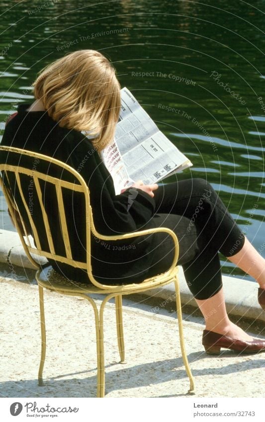 reader Woman Print media Reading Magazine Seating Pond Break Calm Newspaper Revue Human being Sun Sit Chair water young shade