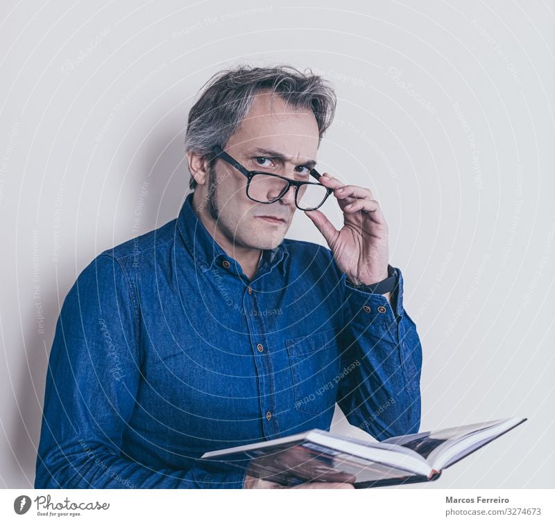 man with presbyopia reading a book Lifestyle Health care Masculine Man Adults Body 1 Human being 30 - 45 years Shirt Eyeglasses Long-haired Facial hair Book