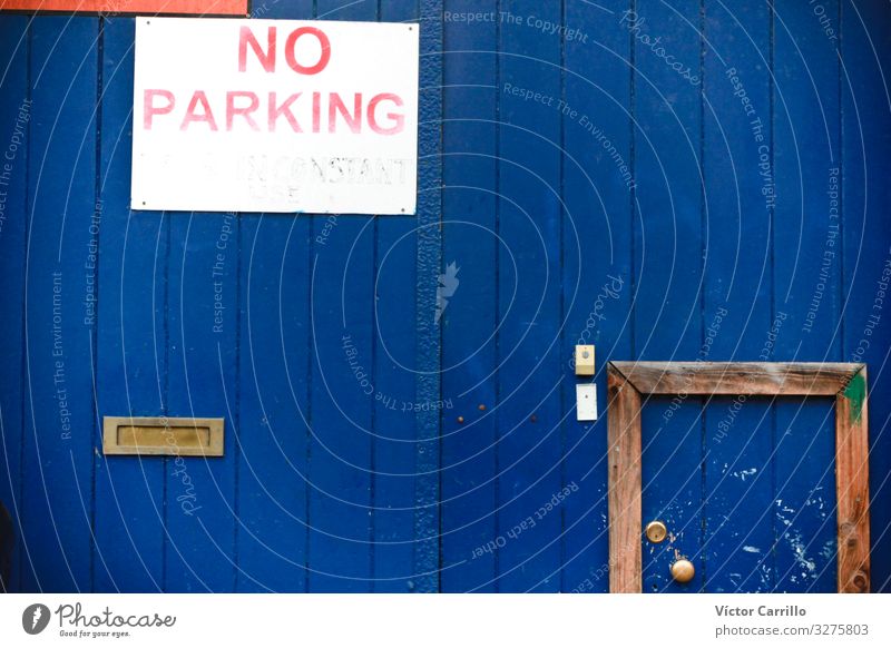 No parking sign in a blue garage door Wood Retro Blue Poverty Decadence Mysterious Serene Kitsch Colour photo Exterior shot Deserted Copy Space right