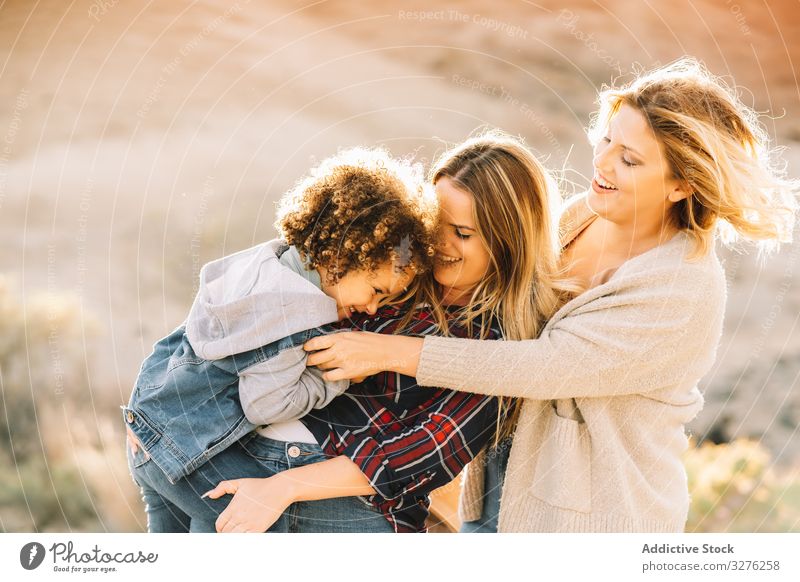 Smiling blond women walking with curly child toddler fun nature play rest smile happy cheerful lifestyle modern bonding love tender casual kid innocence joy