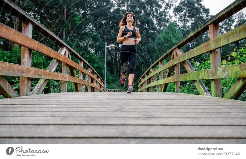 Woman running through an urban park Leisure and hobbies Sports Success Human being Adults Nature Lanes & trails Sneakers Fitness Thin Endurance Effort