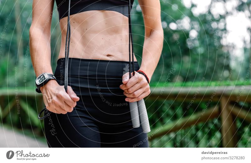 Woman posing with skipping rope in a park Body Sports Human being Adults Nature Park Lanes & trails Fitness Thin Pride Defiant Unrecognizable athlete Posture