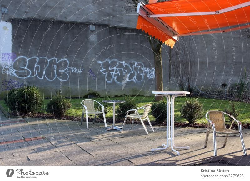 A place in the sun Lifestyle Deserted Wall (barrier) Wall (building) Terrace Graffiti Relaxation Sit Town Orange Table high table Sun blind Weather protection