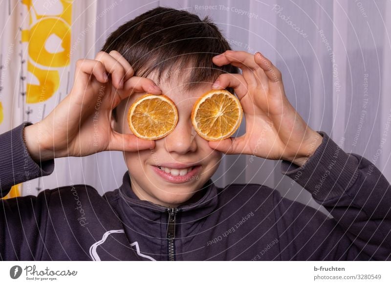 Child with orange slices Boy (child) Face Hand 1 Human being 8 - 13 years Infancy Eyeglasses Utilize Touch To hold on Smiling Laughter Looking Playing Happiness
