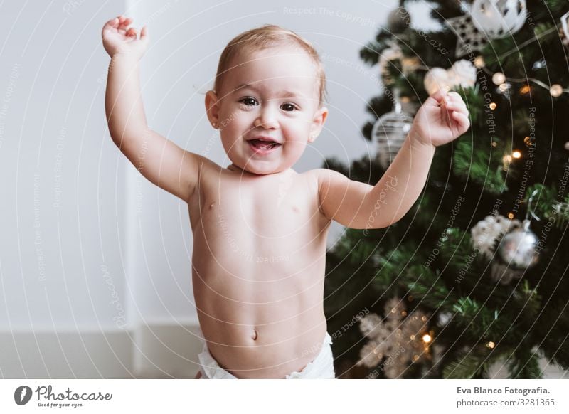 happy baby girl wearing diaper decorating Christmas Tree Lifestyle Joy Happy Winter House (Residential Structure) Decoration Feasts & Celebrations