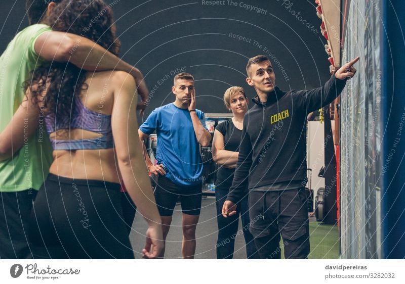Coach explaining to athletes in the gym Lifestyle Sports Blackboard Human being Woman Adults Man Group Fitness Listening Athletic coach Gymnasium Explain