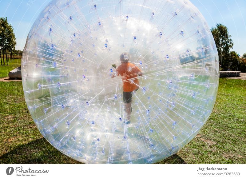 children have fun in the Zorbing Ball Joy Happy Leisure and hobbies Adventure Summer Sun Sports Child Grass Meadow Hill Sphere Drop Movement Fitness Laughter