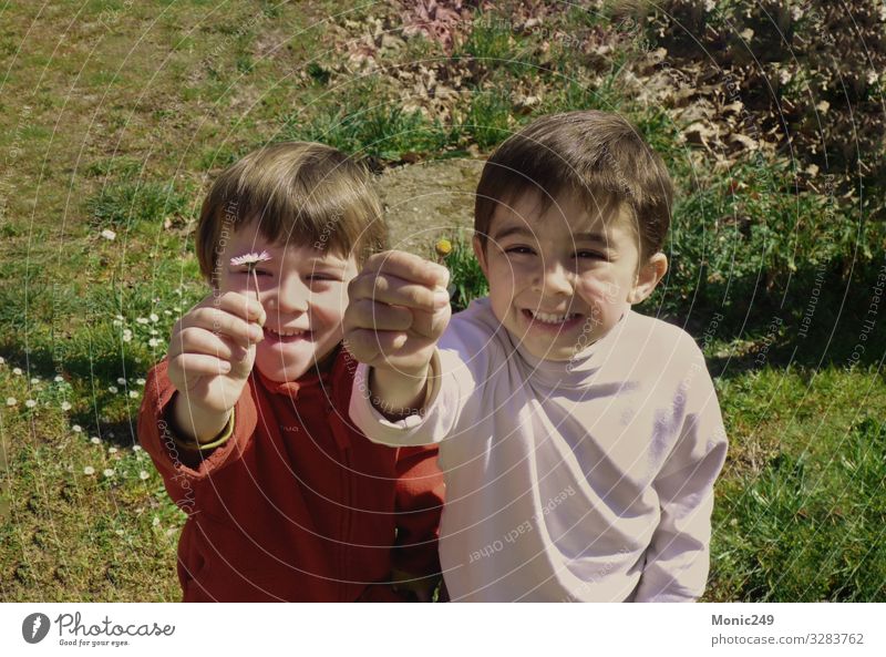 twin children smiling and offering a flower Happy Beautiful Playing Far-off places Mother's Day Birthday Child Camera Human being Baby Family & Relations
