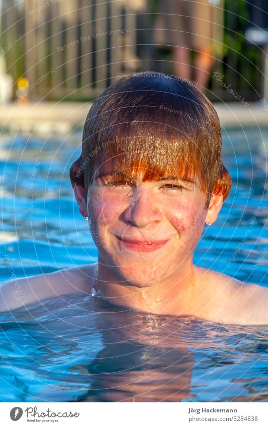 boy has fun in the outdoor pool Joy Happy Face Swimming pool Vacation & Travel Sun Child Boy (child) Youth (Young adults) Warmth Smiling Friendliness Wet Cute