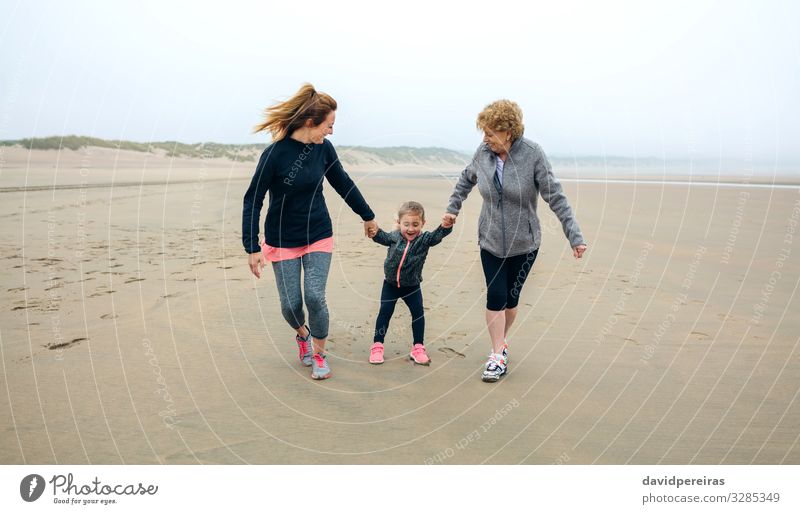 Three female running on the beach in autumn Lifestyle Joy Happy Playing Beach Child To talk Human being Woman Adults Mother Grandmother Family & Relations Sand