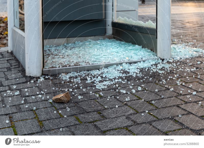 Broken glass and stone in front of a telephone booth Public Phone box Stone Glass Aggression policy Rebellious glass break Glass fragment Lack of inhibition