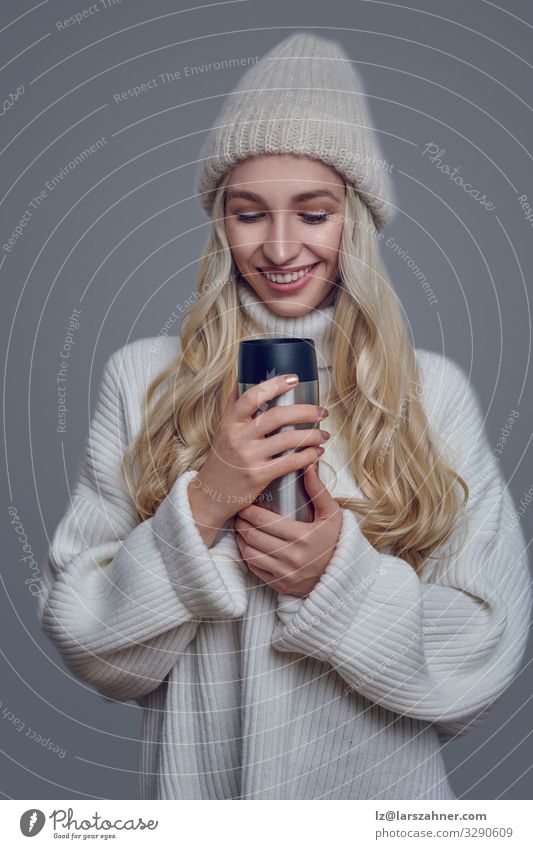 Pretty young woman in a thick woollen sweater and knitted cap Beverage Face Woman Adults 18 - 30 years Youth (Young adults) Sweater Hat Blonde Smiling Hot