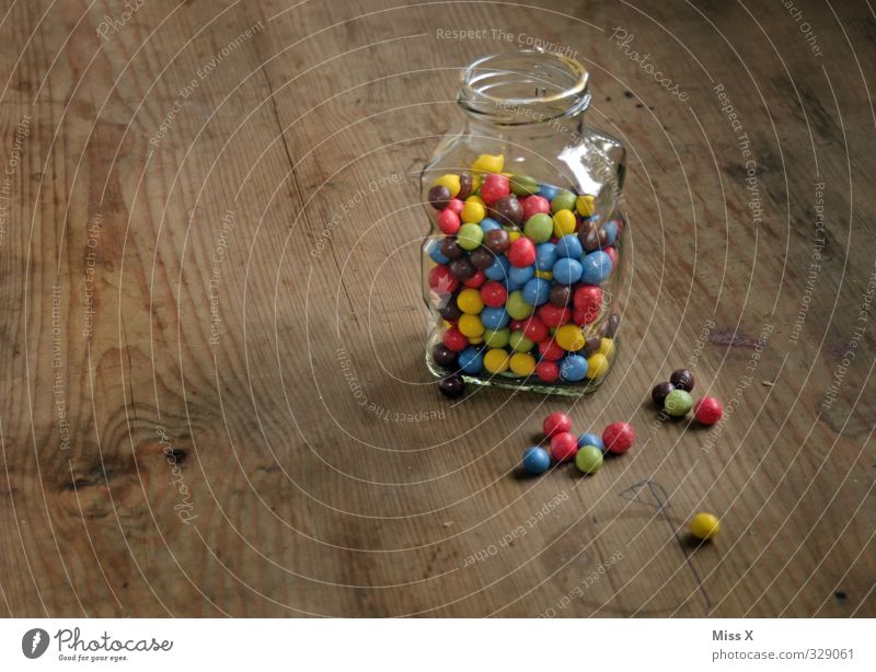 Jar Food Candy Chocolate Nutrition Small Delicious Sweet Multicoloured Chocolate buttons Storage tank Sphere Wooden table Colour photo Interior shot Close-up