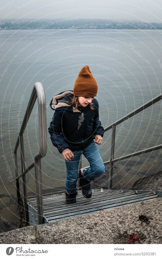 Boy at the lake in winter Boy (child) Child Lake zurich Stairs Water Winter cap winter jacket Movement Exterior shot Colour photo at I'm Day Nature chill Blue