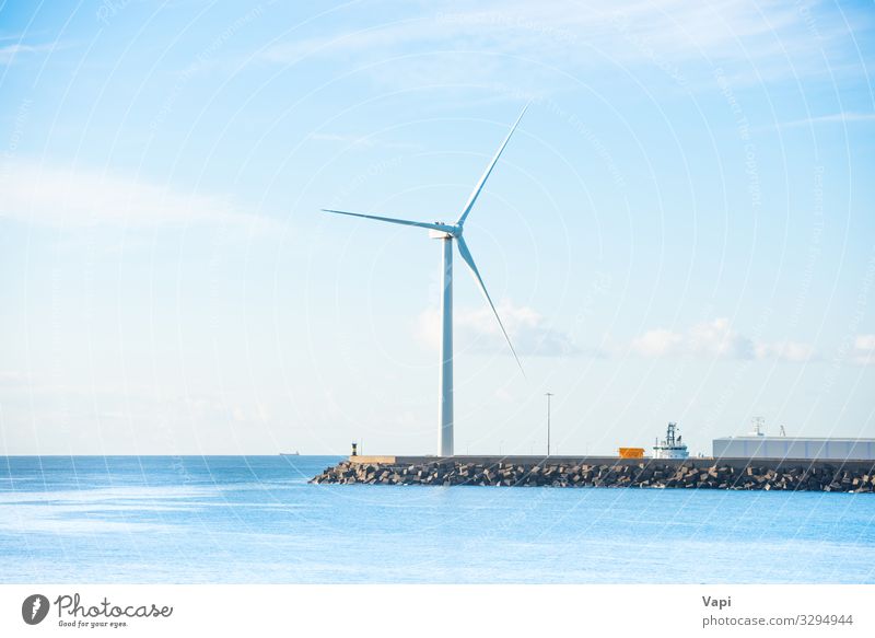Windmill at edge of breakwater Ocean Waves Energy industry Wind energy plant Environment Nature Landscape Sky Clouds Horizon Coast Blue Green Black White