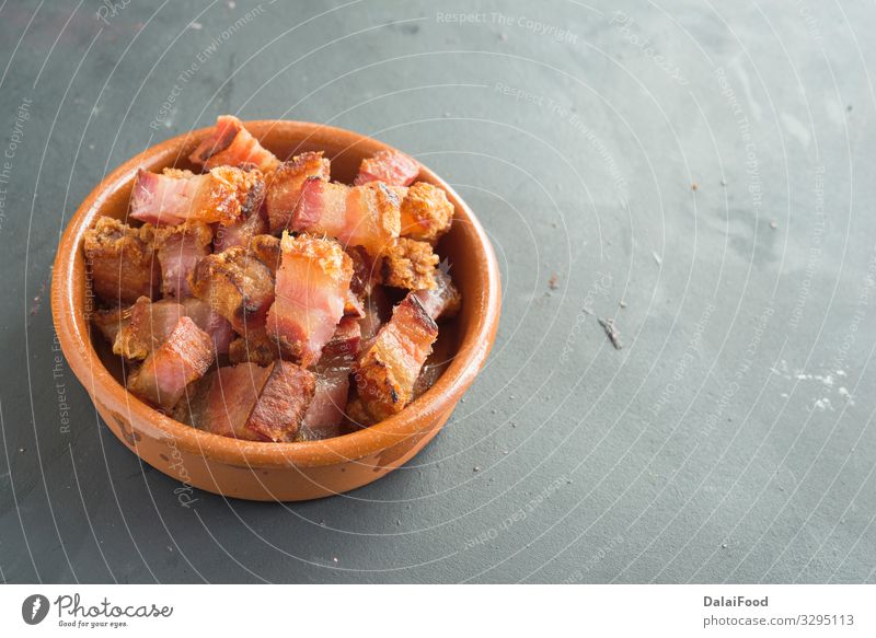 slice of bacon tapa typical spanish food Plate Interest black background Spain torrezno torreznos Colour photo