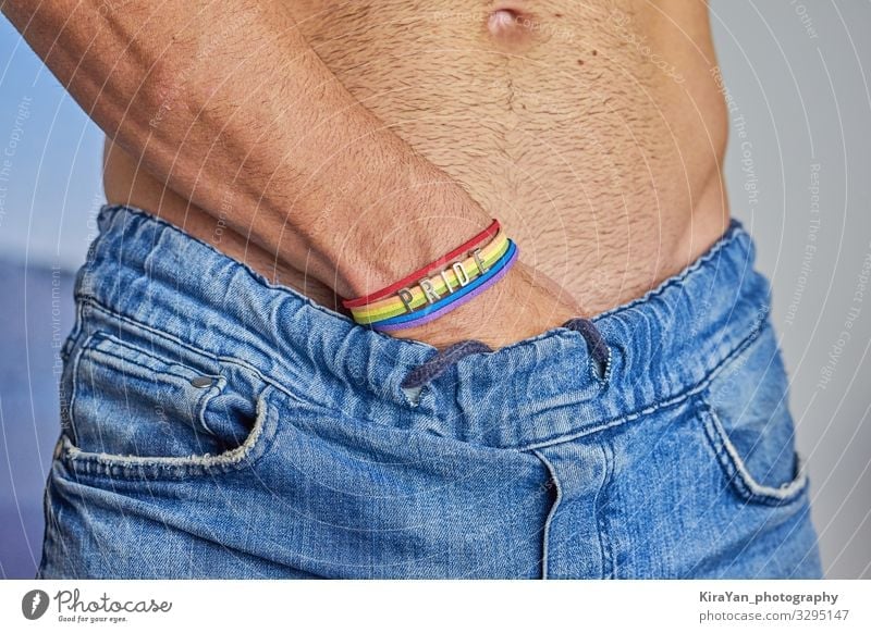 Male hand with rainbow bracelet and text pride Lifestyle Body Freedom Feasts & Celebrations Human being Homosexual Man Adults Arm Hand Flag Touch Love Sex