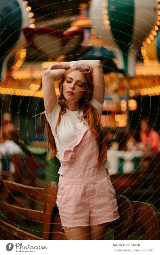 Stylish teenage girl standing in amusement park woman style fashion teenager trendy sensual jumpsuit millennial relax enjoy young careless childish redhead
