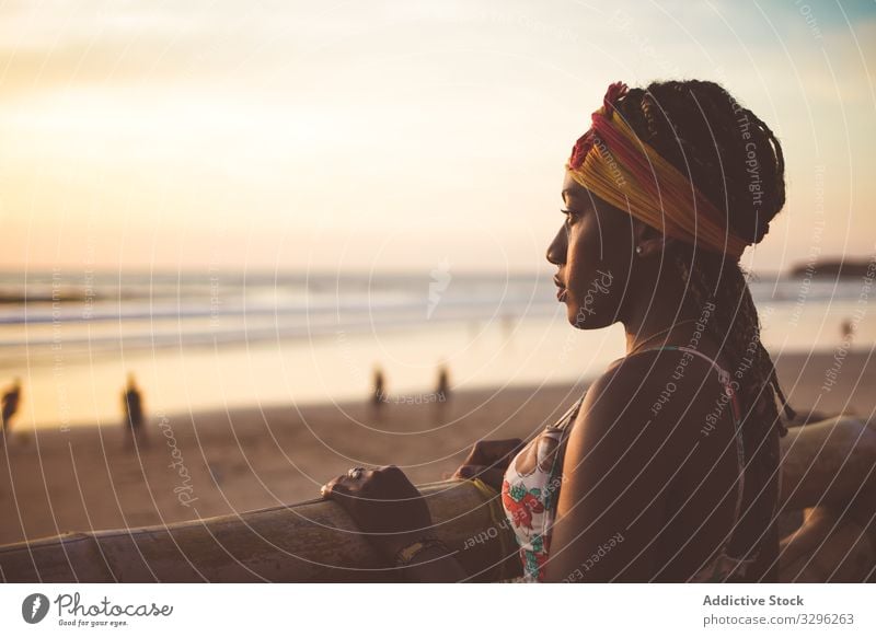 Woman in hat standing on beach and enjoying seascape woman relax tranquil fence ocean calm style female outfit fashion african american black colorful summer