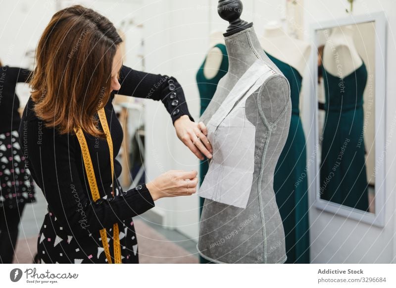 Dressmaker working with mannequin in studio dressmaker workshop woman attach cutout pin clothing designer fashion female tailor occupation craft textile clothes