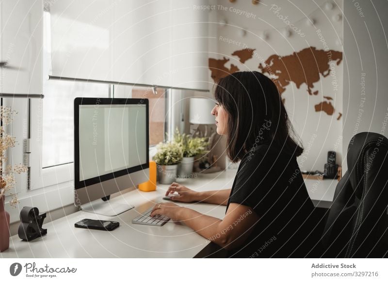 Focused businesswoman using desktop computer in office employee focus screen typing keyboard professional busy female communication connection contact internet