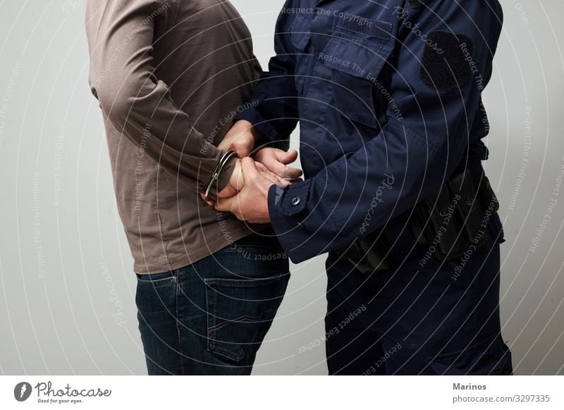 Policeman handcuffing an illigal man. Human being Man Adults Hand Safety Protection Safety (feeling of) Force Handcuff handcuffed guilt crime Criminal