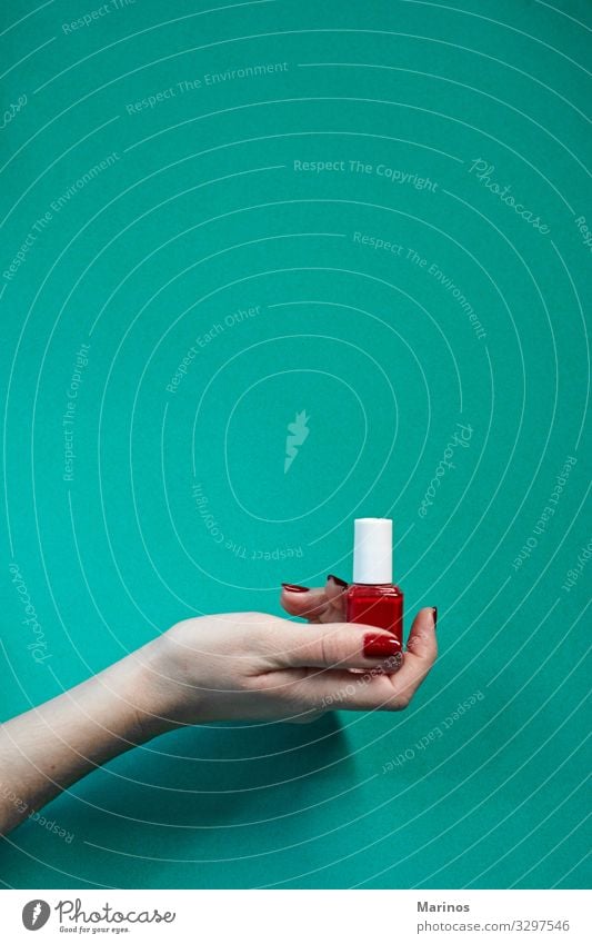 Red polish bottle in woman hand. Bottle Beautiful Manicure Medical treatment Spa Human being Woman Adults Hand Fingers Colour nail care salon trimming