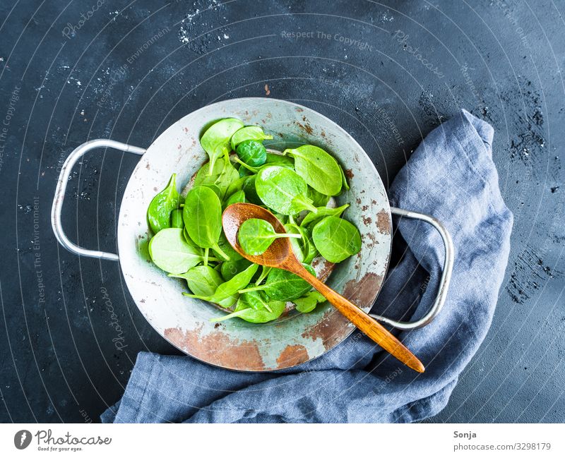 Fresh raw leaf spinach in a frying pan Food Vegetable Spinach Raw Nutrition Lunch Dinner Organic produce Vegetarian diet Diet Pan Spoon Wooden spoon Napkin