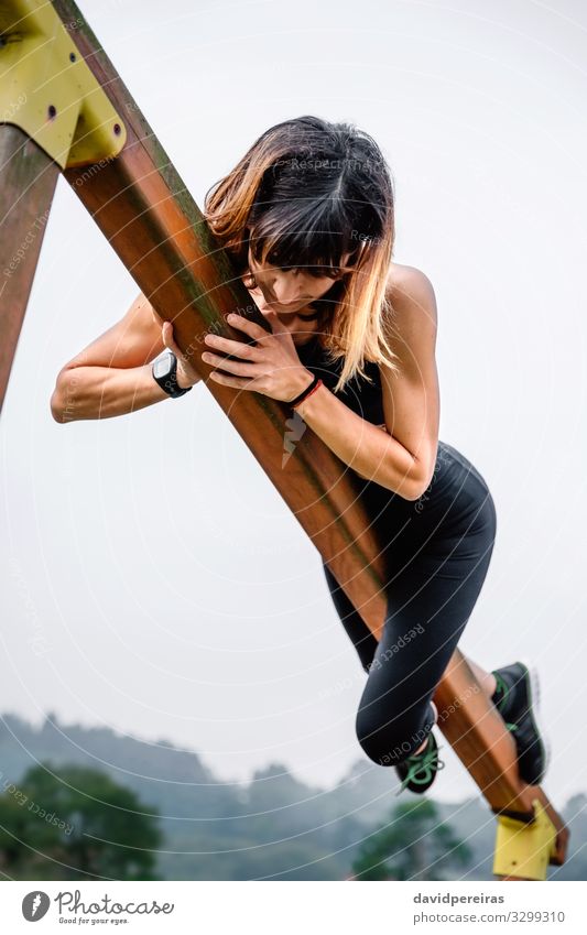 Sportswoman training grabbed to a wooden bar Lifestyle Body Climbing Mountaineering Human being Woman Adults Nature Park Fitness Thin Muscular Strong Power