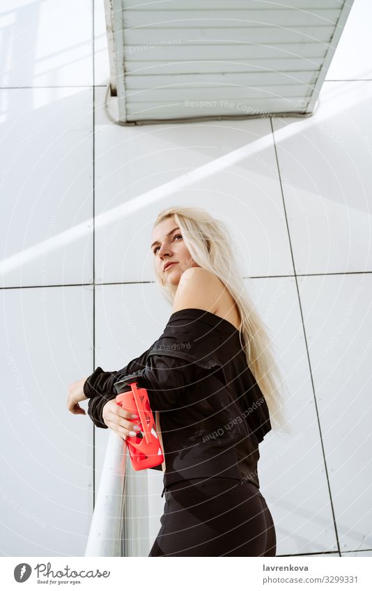 Blonde athlete with a reusable bottle after working out outdoors Action Loneliness Bottle Caucasian City Clothing Young woman Girl Modern Exterior shot Sit Thin