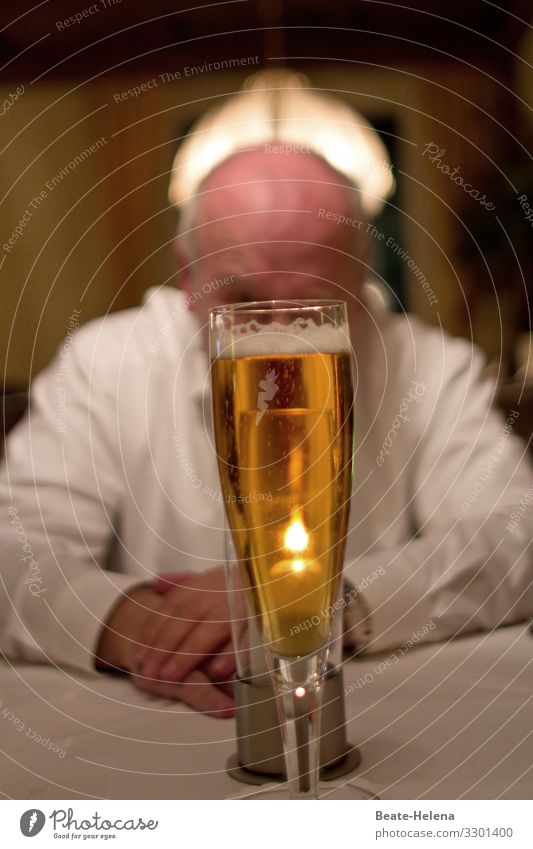 End of work: man lets himself and his beer glass reverently illuminated from the front and behind Closing time white shirt Break end of work relaxation Glass