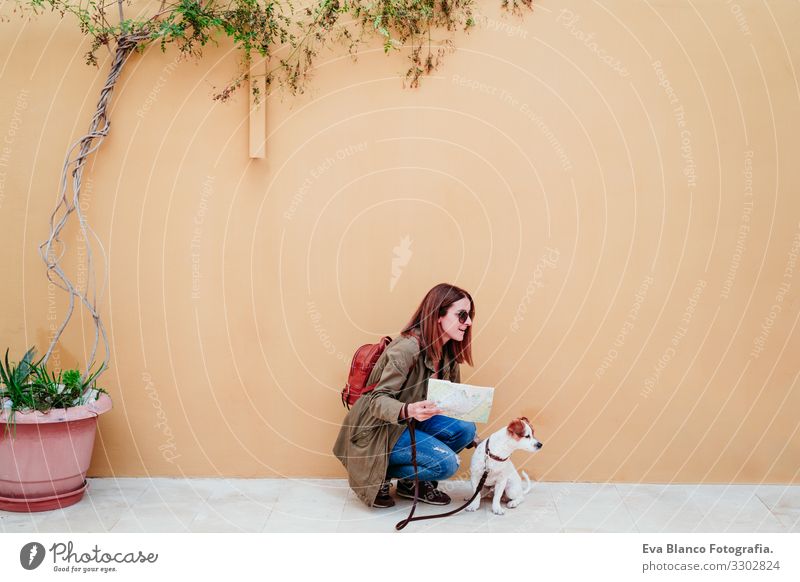 young woman and cute jack russell dog in a city looking a map. travel concept Woman Dog Map yellow background City Multicoloured Background picture