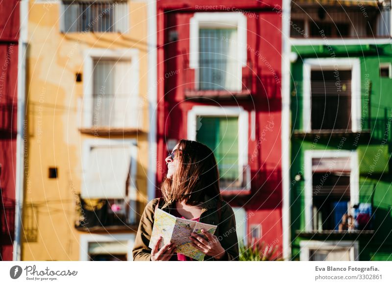young woman holding a map outdoors at sunset. colorful city background. travel concept Woman City Map Multicoloured Background picture Vacation & Travel Tourism