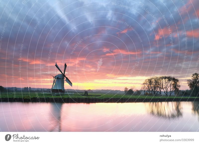 dramatic purple sinrise over windmill by river - a Royalty Free Stock Photo  from Photocase