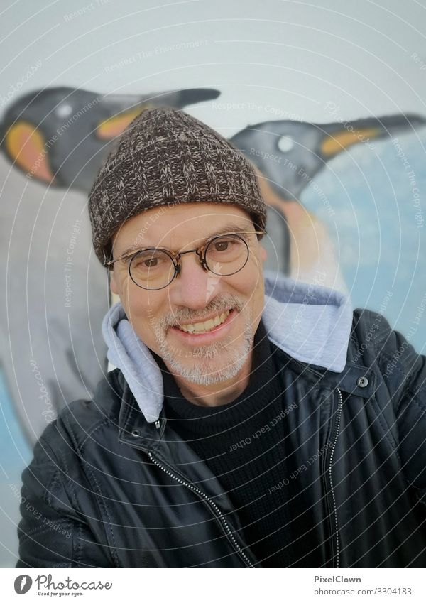 Mann mit Mütze vor einer Graffitiwand Mensch Person Porträit Pinguine urban Großstadt Bart Gesicht Kaputze