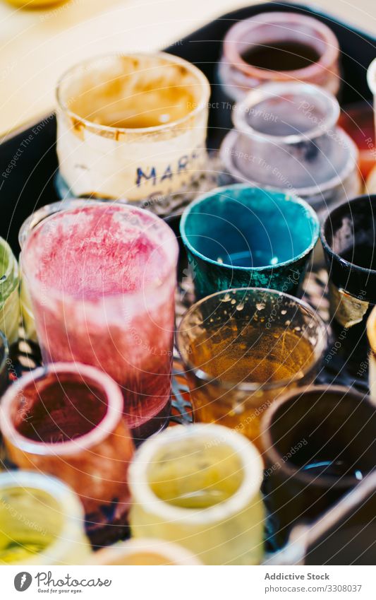 Glass cups with paints in workshop can palette multicolor glass lacquer diverse prepare mix shade used process composition arrangement layout inspiration art