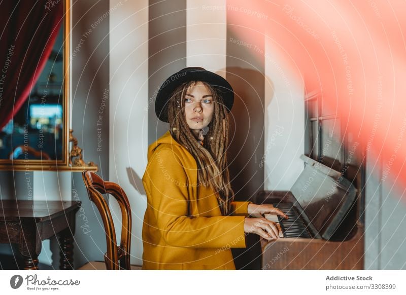 Hipster millennial woman playing piano dreadlocks hipster music stylish serious sit female focused concentrated practicing musician instrument art pianist