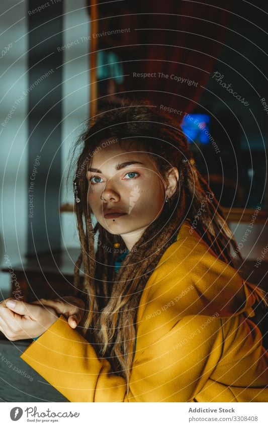 Pensive hipster woman looking away pensive thoughtful young millennial modern dreadlocks serious sit stylish style fashion female portrait think dream casual