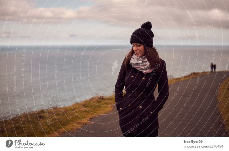 Portrait of a young woman in winter walking by the sea Lifestyle Elegant Style Happy Beautiful Vacation & Travel Adventure Summer Winter Mountain Garden