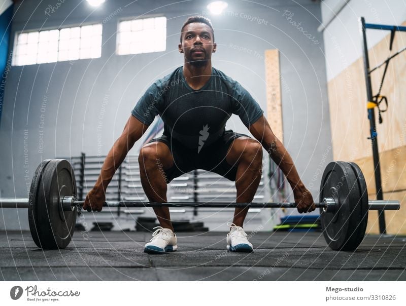 Crossfit athlete doing exercise with a barbell. Lifestyle Body Sports Man Adults Fitness Athletic Muscular Strong Black Power Concentrate Barbell workout