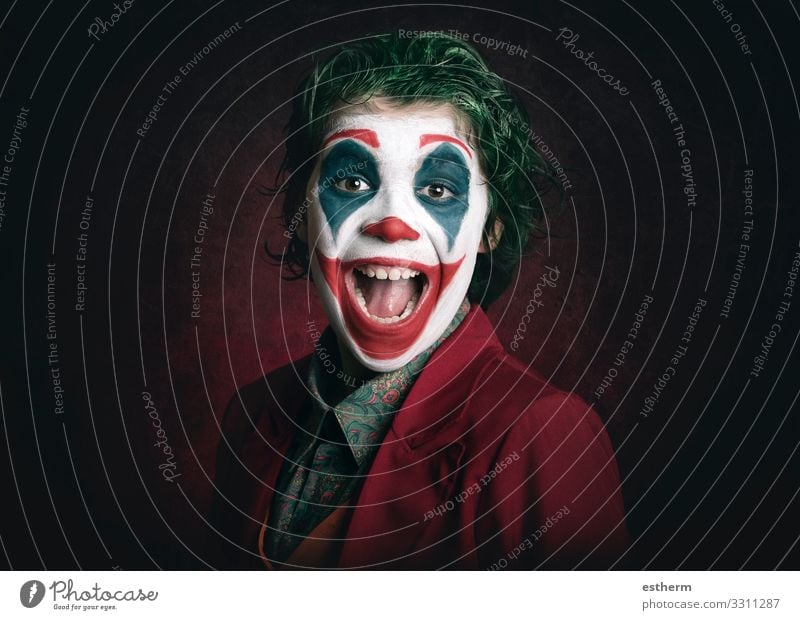 smiling boy dressed as Joker on dark background Lifestyle Joy Make-up Playing Entertainment Party Event Feasts & Celebrations Carnival Hallowe'en Human being