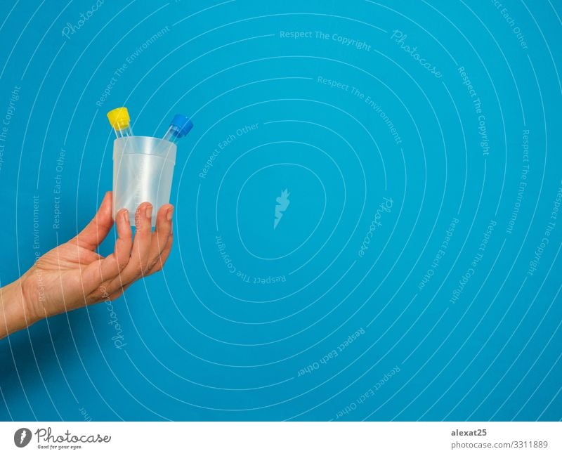 Hand with analysis tubes on blue background with copy space Bottle Health care Illness Medication Science & Research Laboratory Examinations and Tests Container