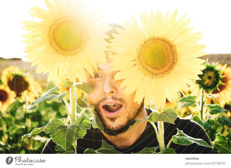Young man enjoying the day in a field of sunflowers Face Life Sun Human being Masculine Man Adults Nature Spring Weather Beautiful weather Flower Beard To enjoy