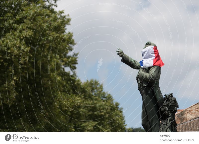 Sculpture with veiled face Town Tourist Attraction Monument Flag Tricolor Packaged Envelop Movement Threat Rebellious Bravery Optimism Serene Disciplined