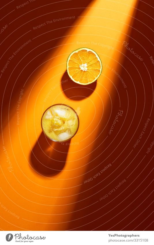 Glass of orange juice and sliced orange in sunlight. Fruit Orange Cold drink Lemonade Juice above view citrous Citrus fruits colorful cut in half flat lay