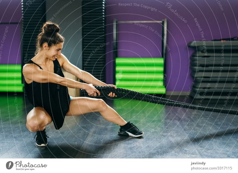 Young and athletic woman using training ropes in a gym. Lifestyle Personal hygiene Body Wellness Club Disco Sports Rope Human being Feminine Young woman